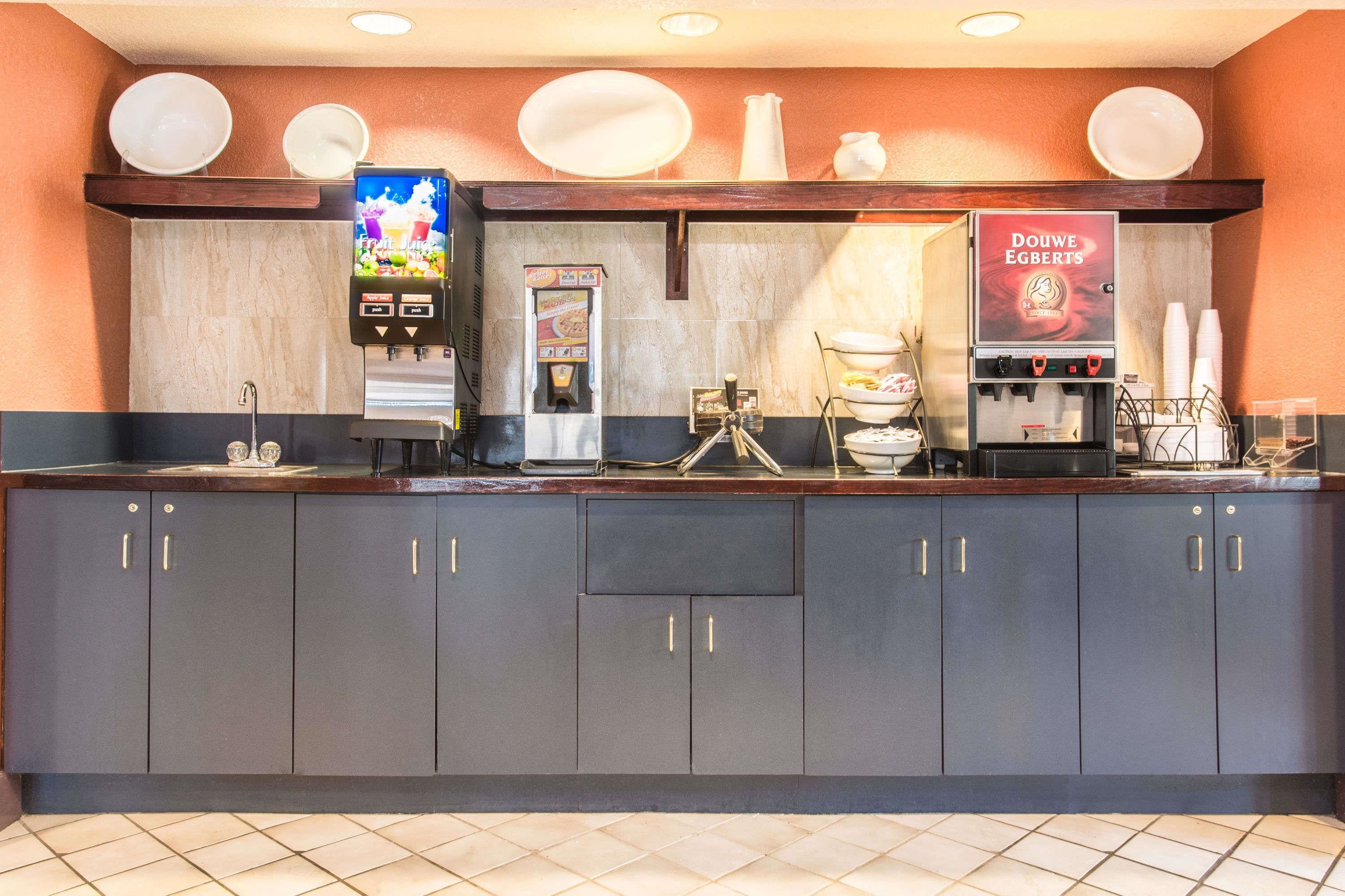 A counter with a coffee machine, a Douwe Egberts vending machine, and a food dispenser.