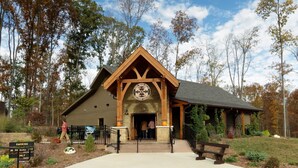 A lodge with a stone facade, wooden beams, and a circular emblem above the entrance. - Holiday Inn Columbus by IHG (Columbus)