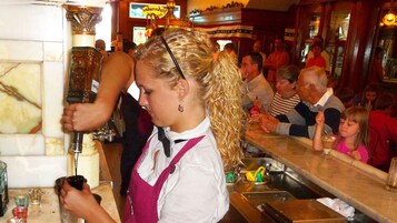 Un bar con un bartender preparando bebidas.
