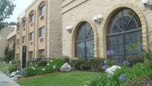 A multi-story building with arched windows and a stone facade. - Portside Inn & Suites (San Pedro)