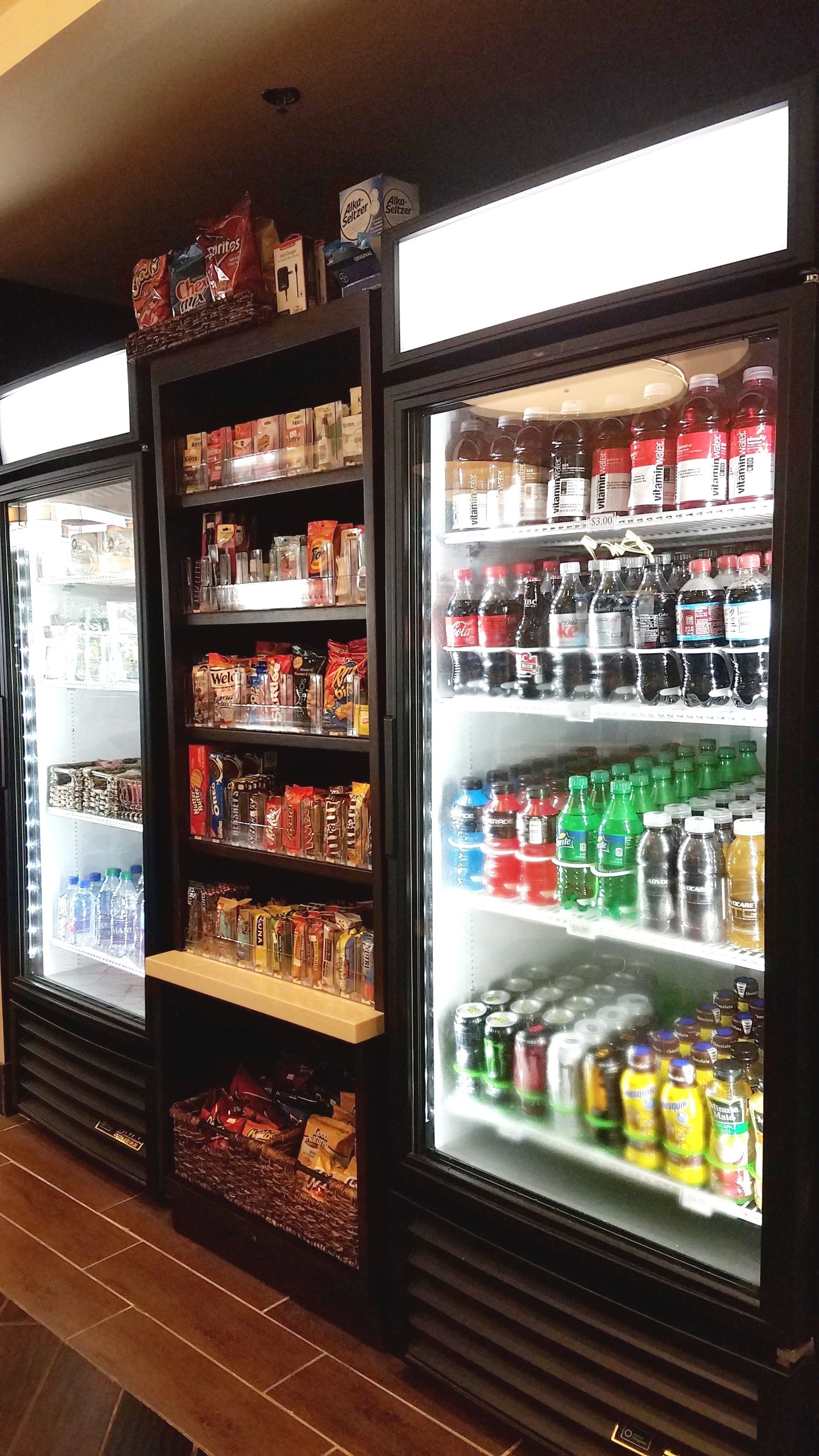 A refrigerated display case with various beverages and snacks.