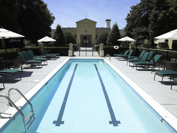 Una piscina al aire libre, tumbonas