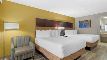 A hotel room with a large bed, a chair, a floor lamp, and a painting on the wall.