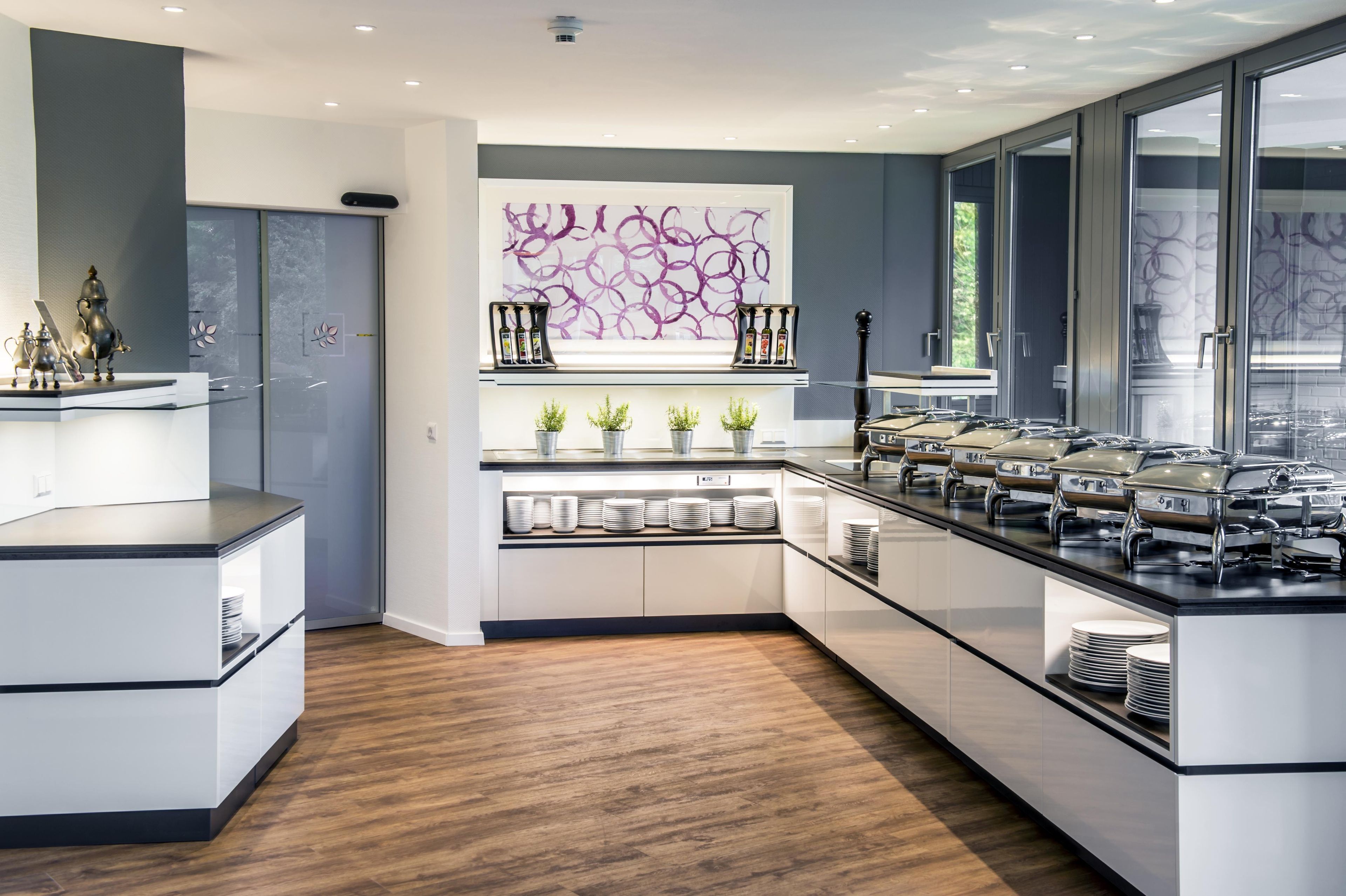 Una cocina moderna con una isla central, electrodomésticos integrados y un elemento decorativo en la pared.