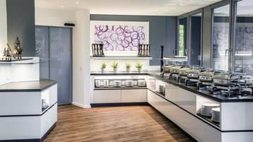 Una cocina moderna con una isla central, electrodomésticos integrados y un elemento decorativo en la pared.