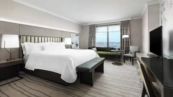 Una habitación de hotel moderna con una cama grande, un escritorio, una silla y una televisión.