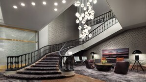 A modern interior with a spiral staircase, a large abstract painting, and a patterned carpet. - The Westin New Orleans (New Orleans)