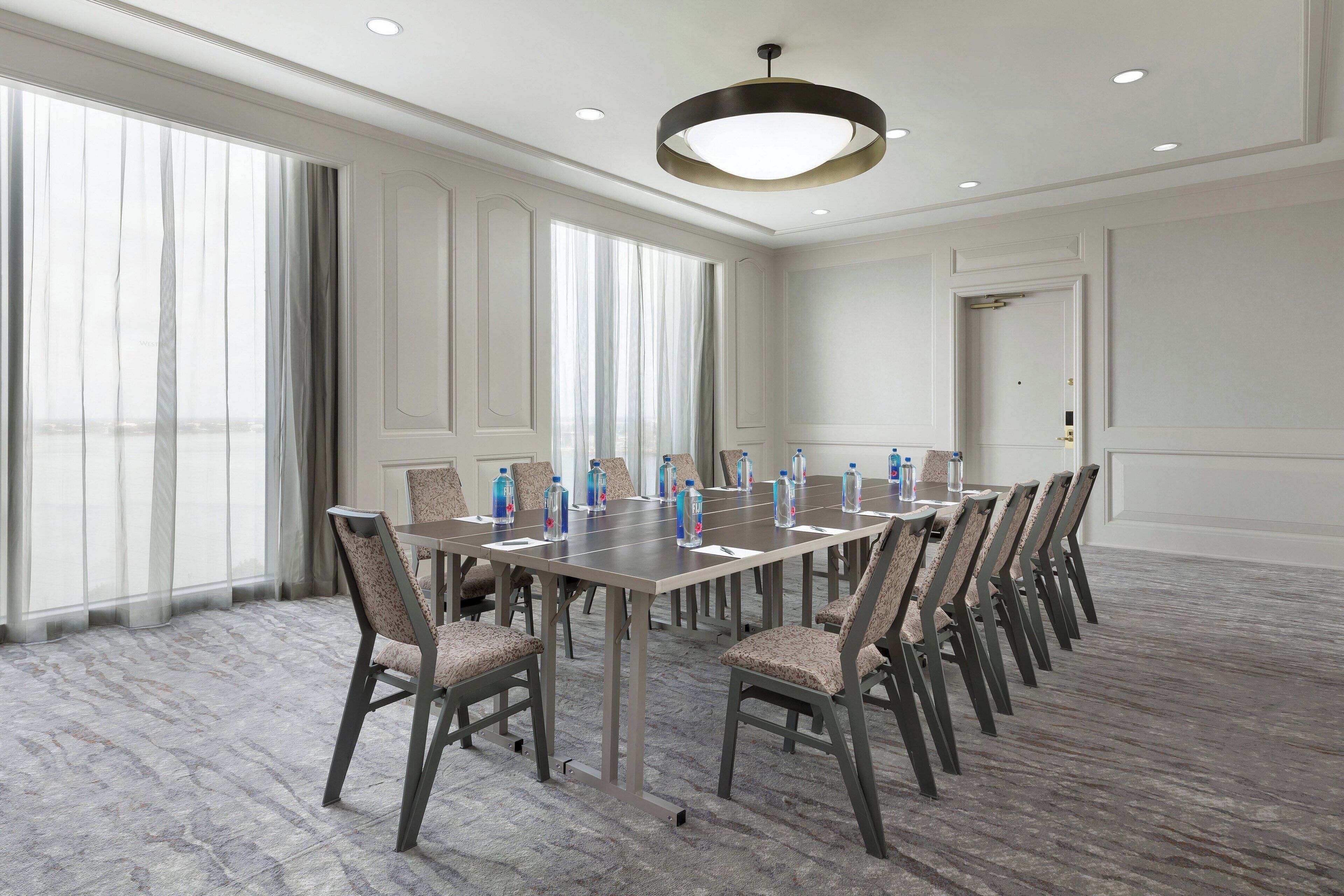 A conference room with a long table, chairs, and water bottles.
