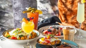 A breakfast setting with various dishes, drinks, and a cozy seating area.