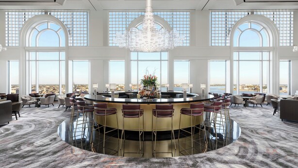 A spacious lounge area with a central bar, large windows, and a high ceiling. - The Westin New Orleans (New Orleans)