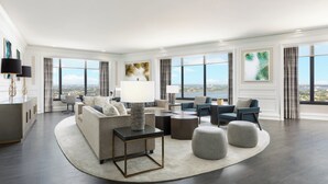 A spacious living room with a large window, a sofa, a coffee table, and a lamp. - The Westin New Orleans (New Orleans)