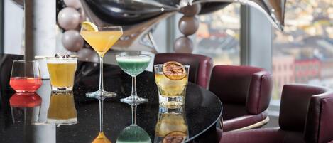 A bar area with various drinks and a city view.