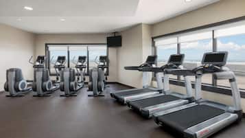 Un gimnasio con cintas de correr, elípticas y máquinas de remo.