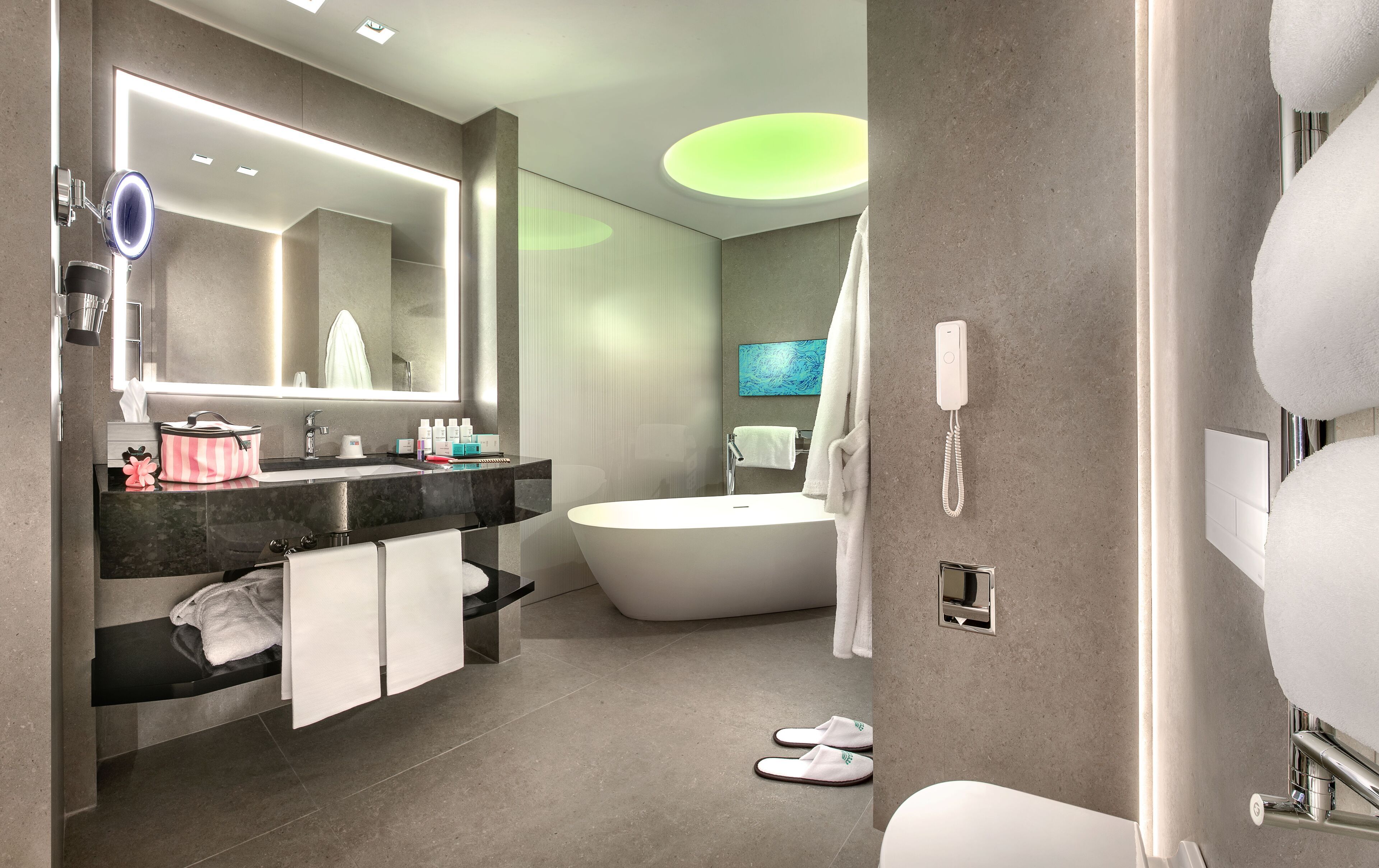 Un bagno moderno con uno specchio grande, un mobile lavabo, una vasca e il water.
