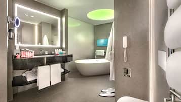 Un bagno moderno con uno specchio grande, un mobile lavabo, una vasca e il water.