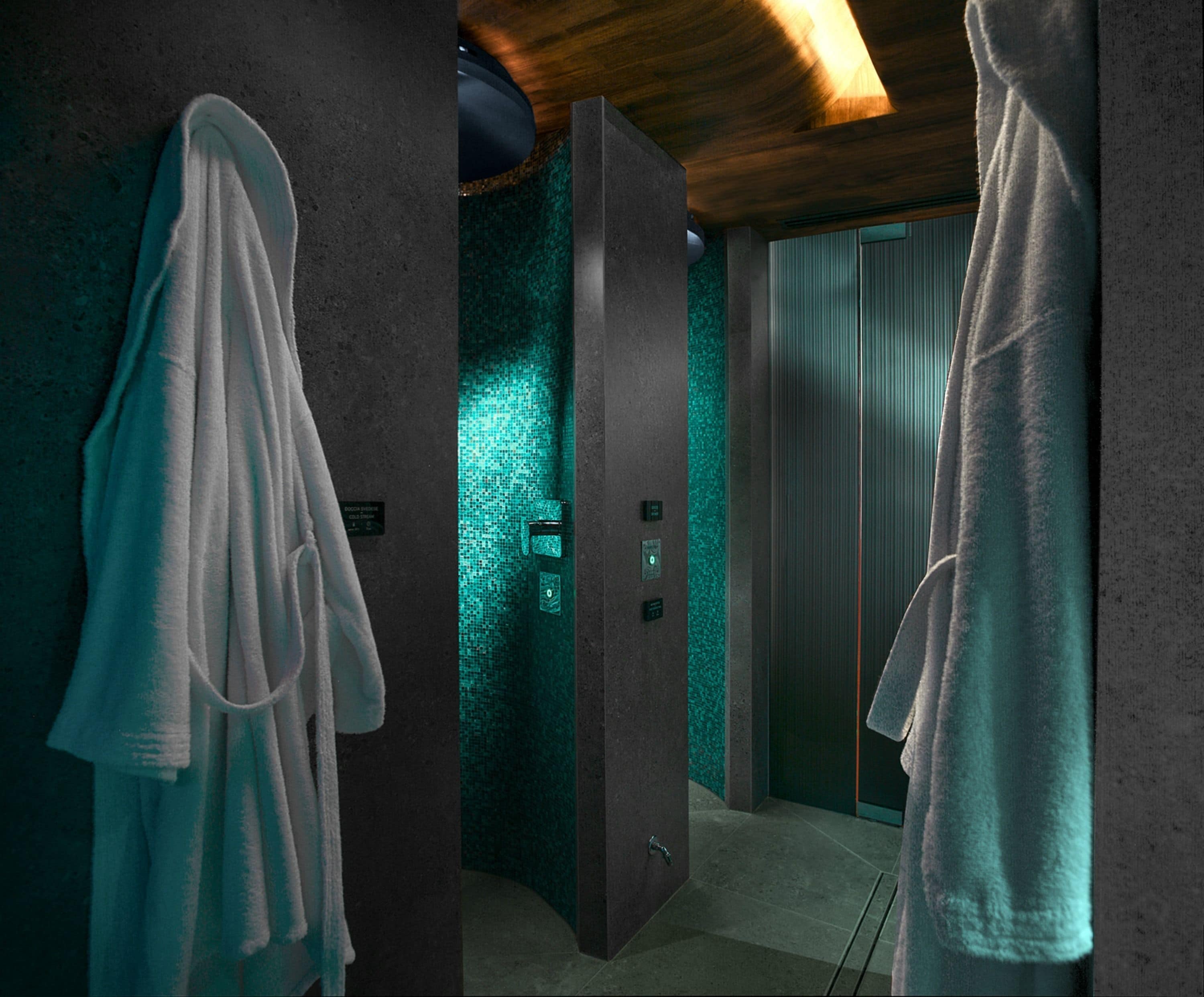Un baño moderno con un letrero de suelo mojado, un perchero para toallas y una zona de ducha.