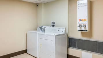 A laundry area with a washing machine and dryer, a water softener unit, and a vented exhaust system.