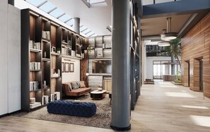 A spacious, modern interior with a large bookshelf, a comfortable seating area, and a high ceiling with skylights. - Crowne Plaza Hotel Foster City - San Mateo by IHG (Foster City)