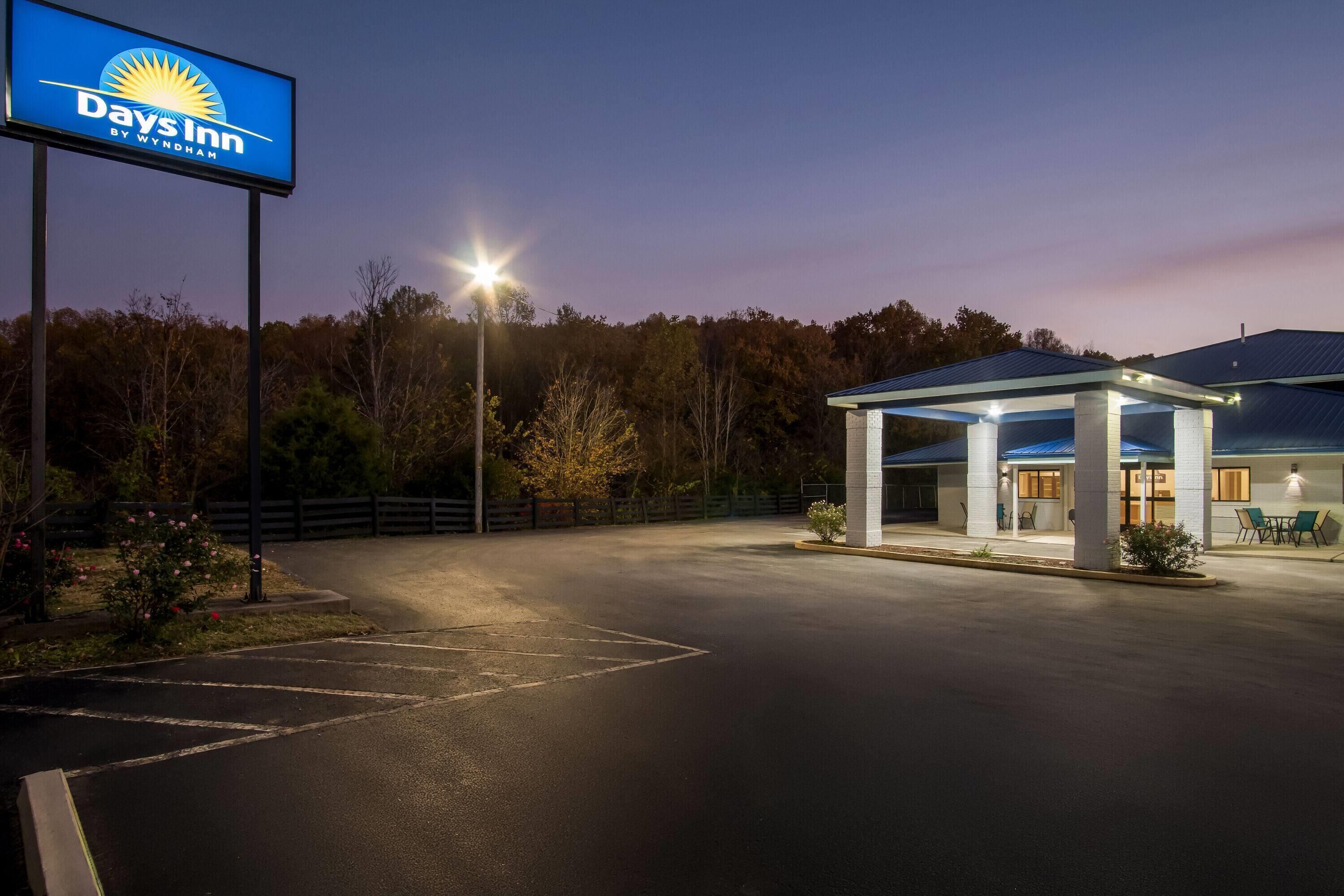 Un Days Inn by Wyndham con zona de estar al aire libre cubierta y aparcamiento.
