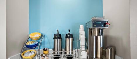 Una estación de café con varias máquinas de café, tazas y recipientes.