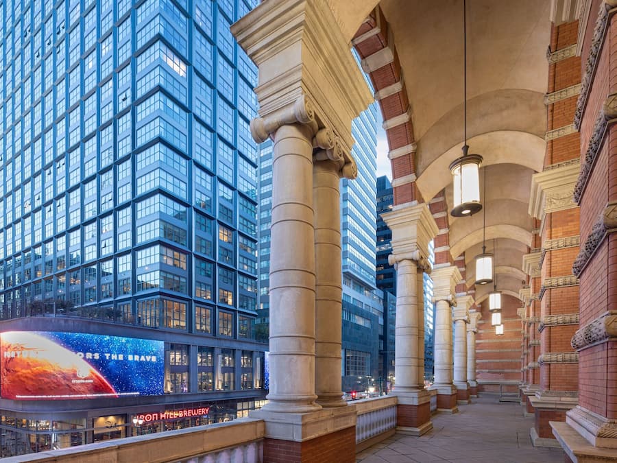 A modern building with large glass windows and classical columns.