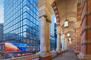 A modern building with large glass windows and classical columns.