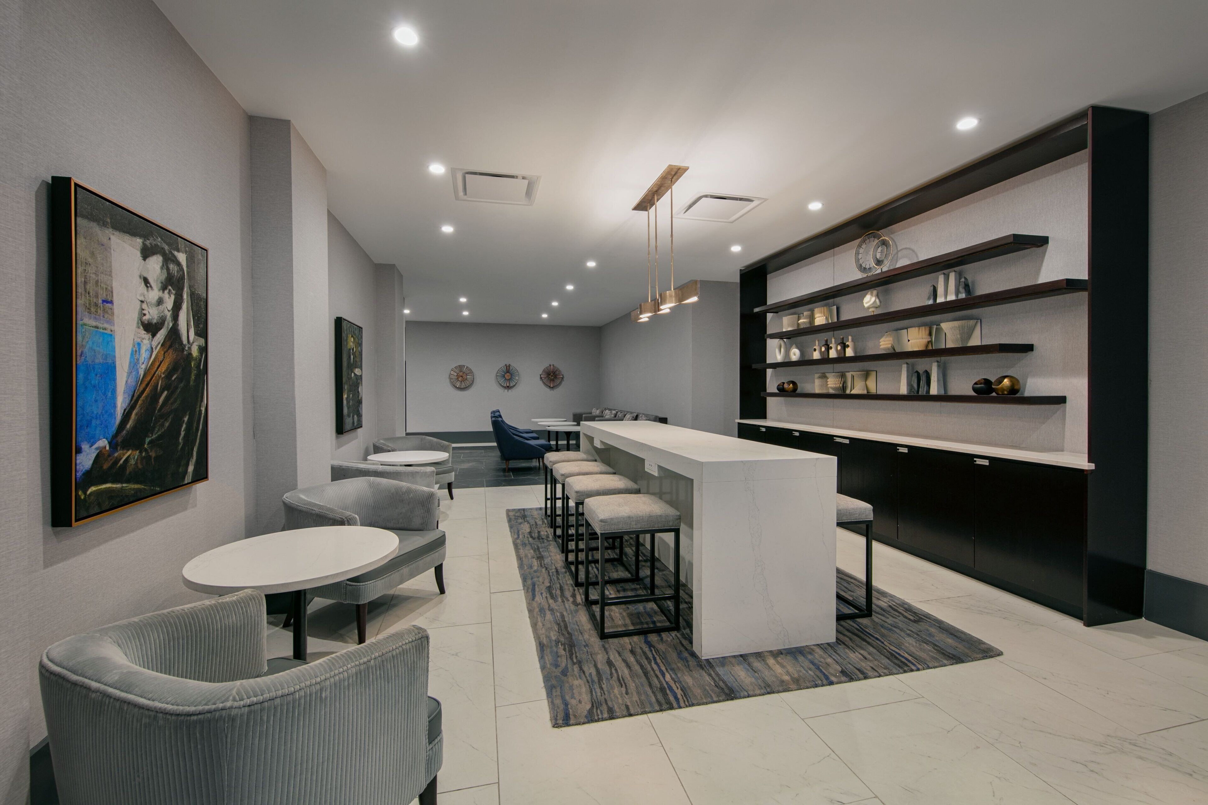 Un interior moderno con una zona de bar, asientos y obras de arte en las paredes.