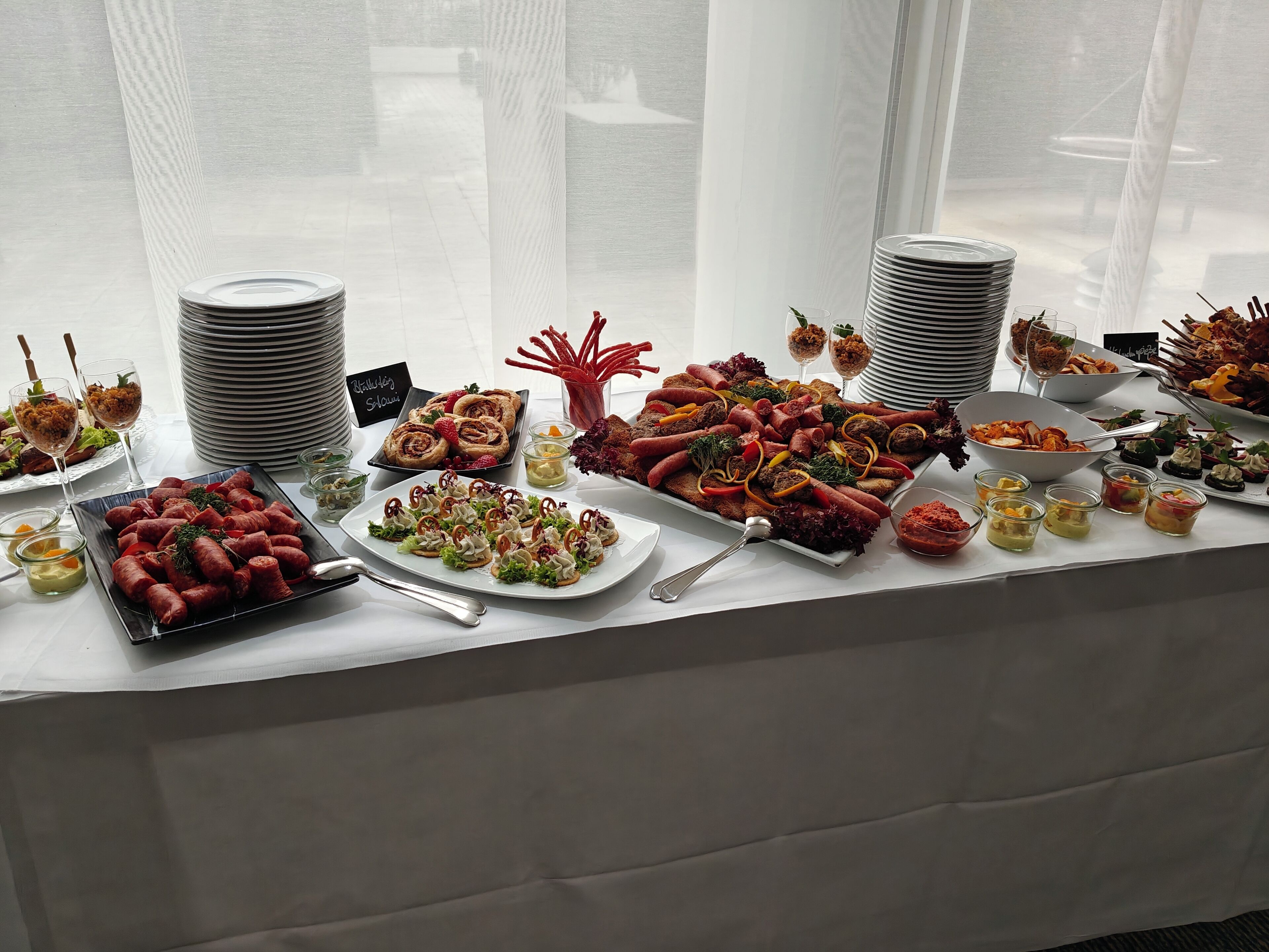 Una mesa de buffet con diversos platos y un cartel que dice 'Wurstsalat'.