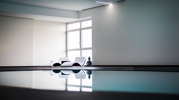 A modern, minimalist room with a large window, a reflective floor, and a statue. - Mercure Hotel Luedenscheid (Luedenscheid)
