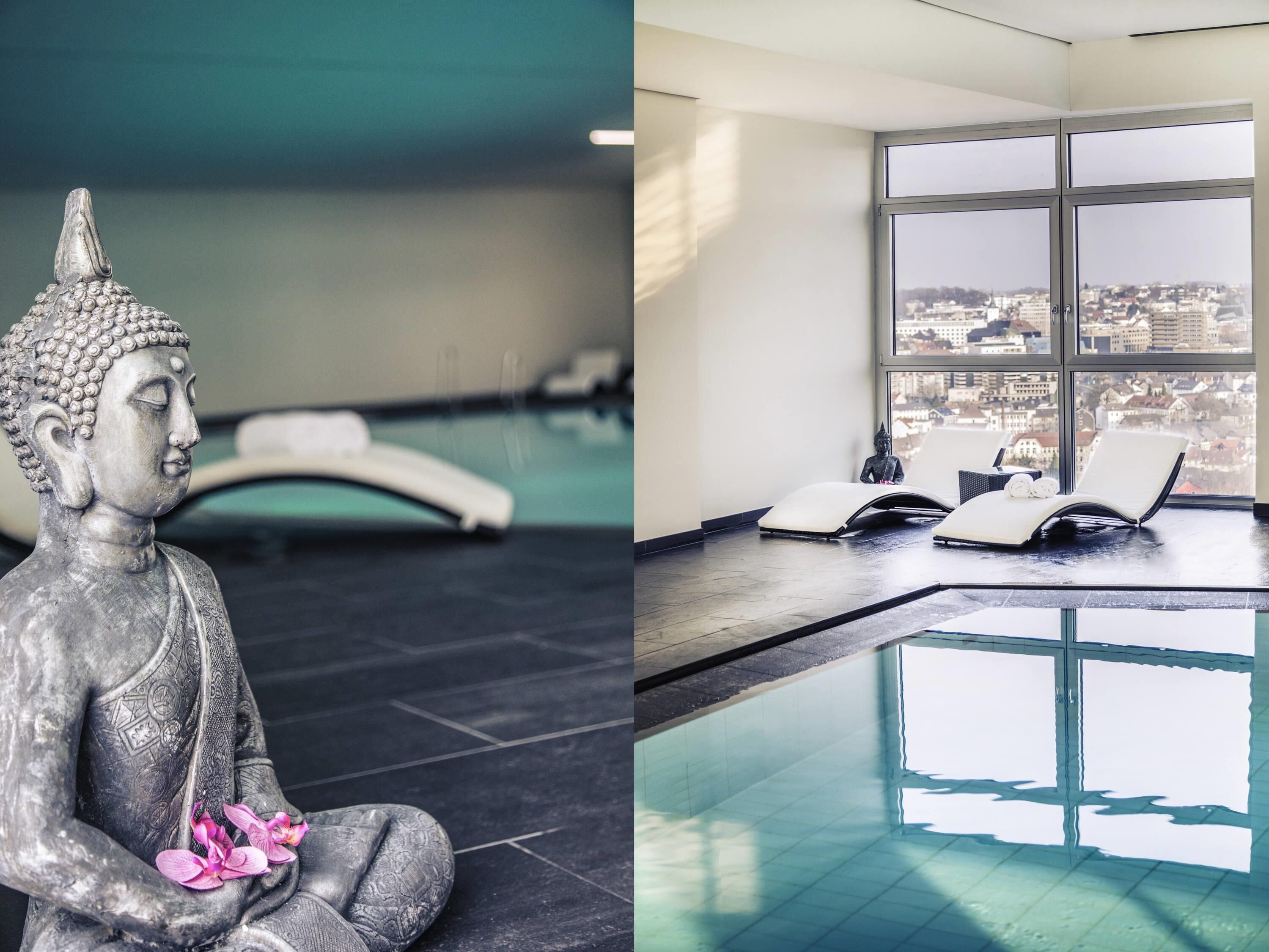 A statue of a seated figure with a lotus flower, a pool, and a lounge area with a view of a cityscape.