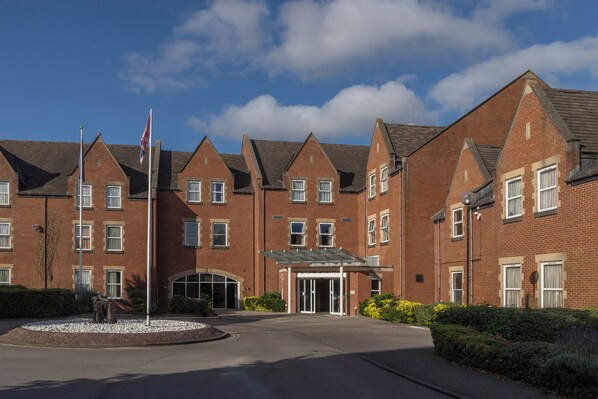 A red-brick building with a central entrance, multiple windows, and a flagpole. - Cheltenham Chase Hotel & Spa (Cheltenham)