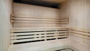 A sauna with wooden benches and a sloped ceiling.