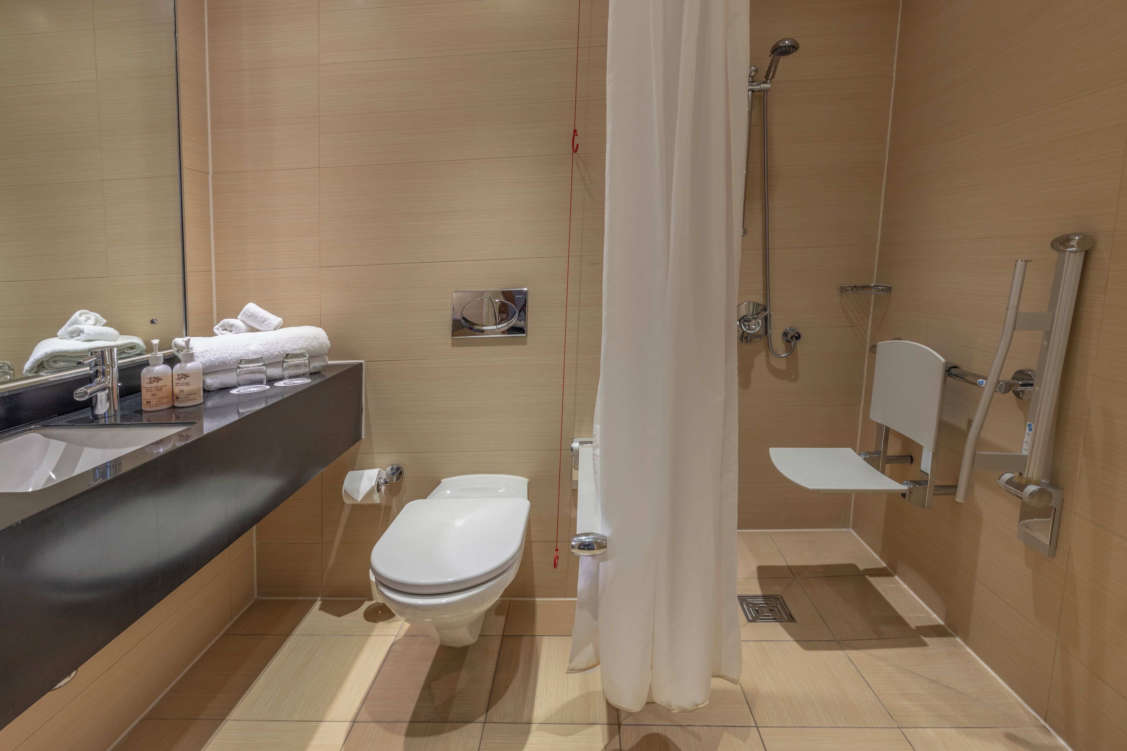 A modern bathroom with a sink, toilet, and shower area.