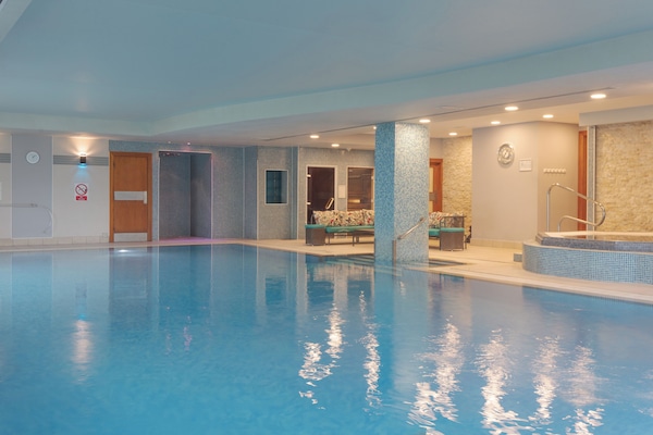 Una piscina cubierta, una piscina al aire libre