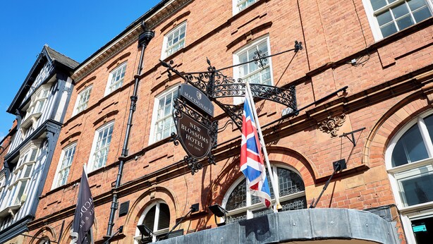 A historic building with a sign for the 'New Blossoms Hotel' and a flagpole with a flag. - Macdonald New Blossoms Hotel, Chester (Chester)