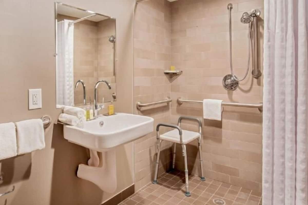 Een bad/douchecombinatie, designer toiletartikelen, een haardroger