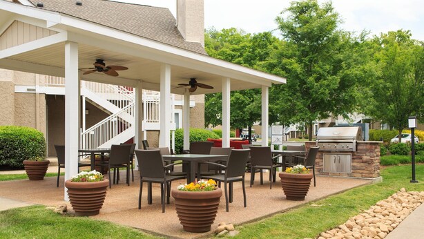 An outdoor patio with a covered seating area, a barbecue grill, and potted plants. - Residence Inn by Marriott Nashville Airport (Nashville)