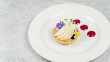 Un postre sobre un plato blanco, con un fondo de mármol.