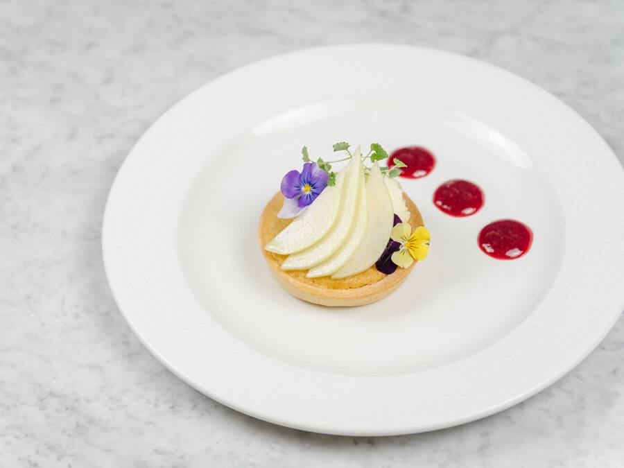 Un postre sobre un plato blanco, con un fondo de mármol.