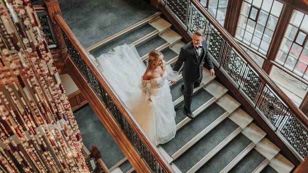A grand staircase with a bride and groom ascending.