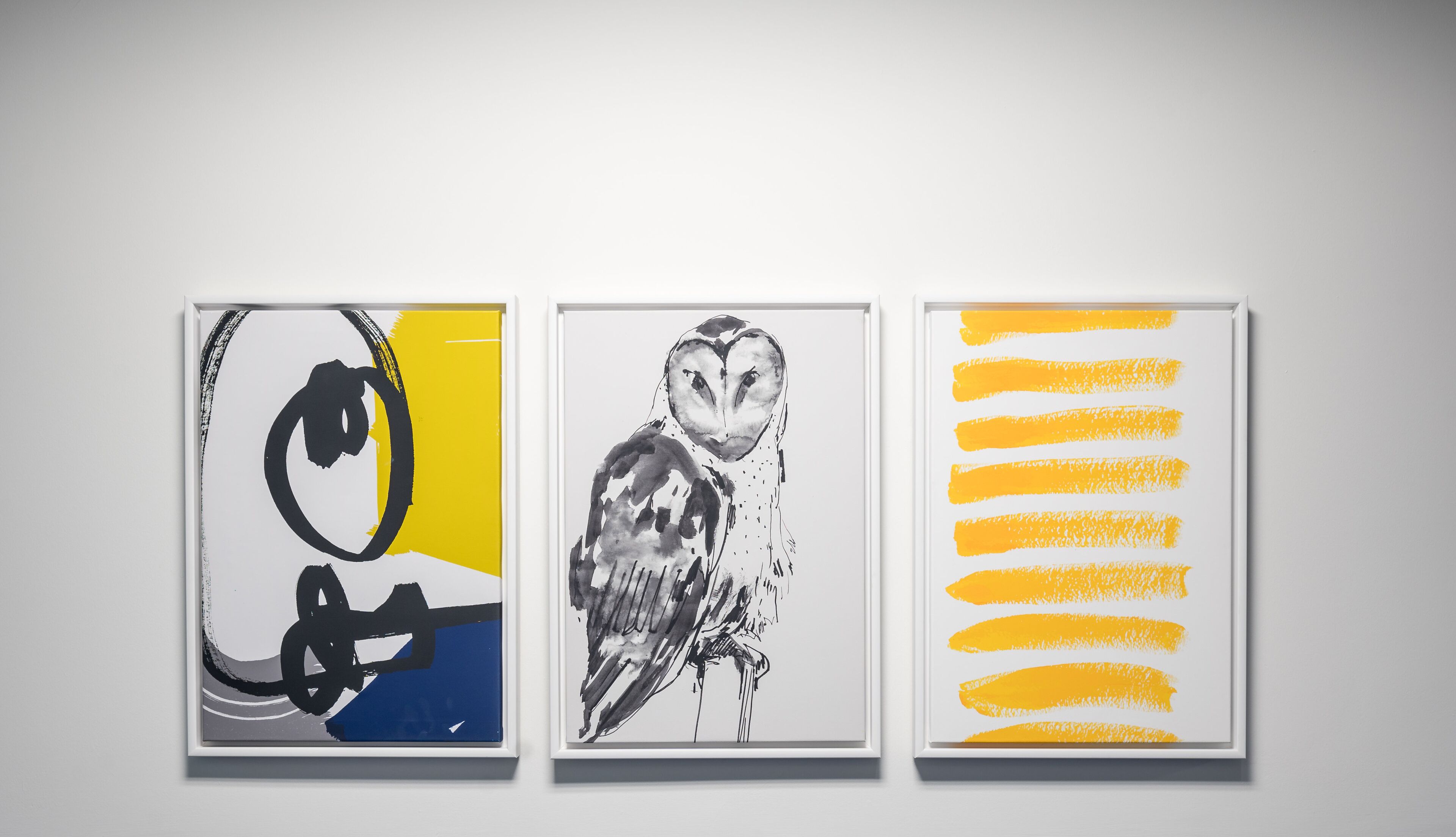 Three framed artworks on a wall.
