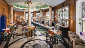 A bar area with marble columns, a patterned floor, and a variety of seating arrangements. - voco Grand Central Glasgow by IHG (Glasgow)
