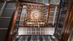 A grand staircase with ornate railings and a central light fixture.