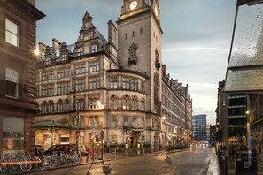 A historic building with a clock tower, large windows, and a corner entrance. - voco Grand Central Glasgow by IHG (Glasgow)