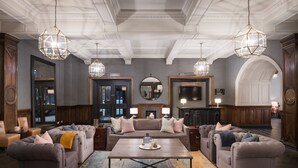 A spacious lobby with a central seating area, a fireplace, and a large mirror. - voco Grand Central Glasgow by IHG (Glasgow)