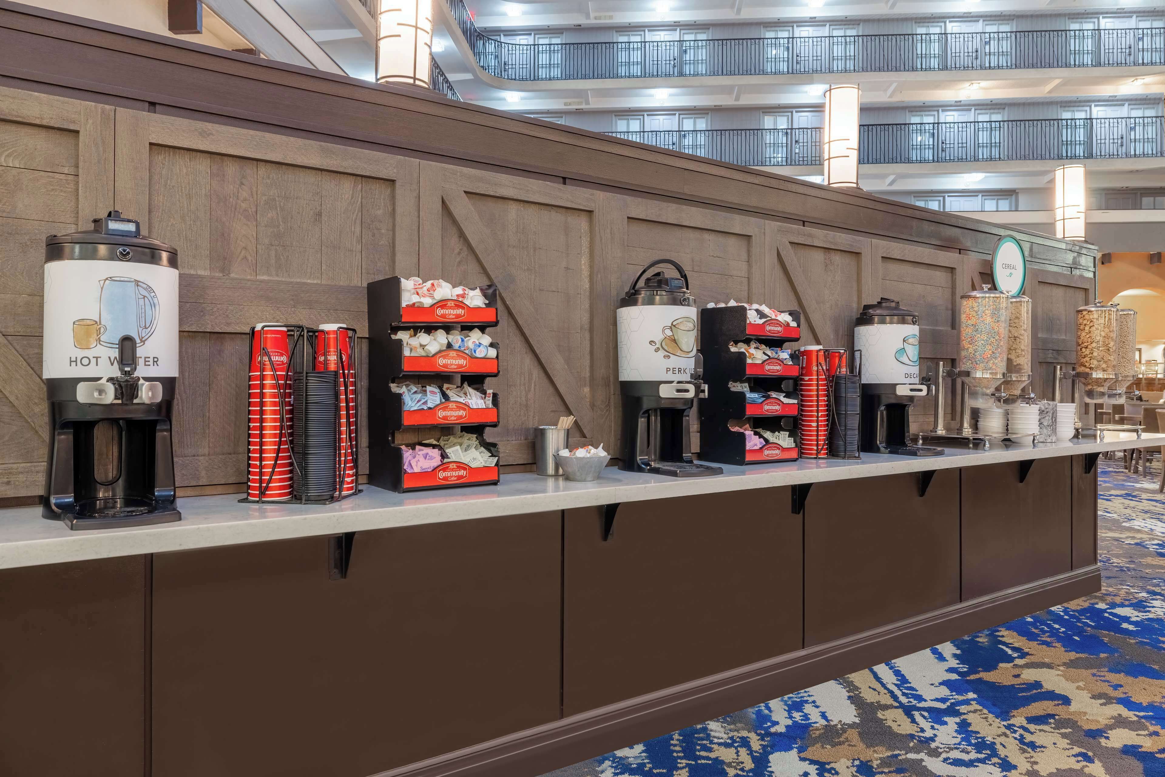 A hotel reception area with multiple coffee machines and beverage dispensers.