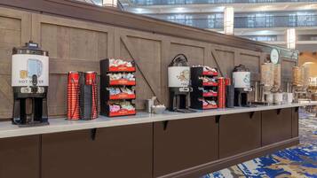 A hotel reception area with multiple coffee machines and beverage dispensers.