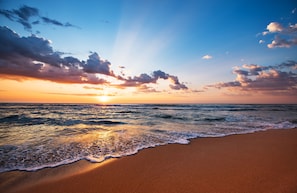 Una playa con olas al atardecer.