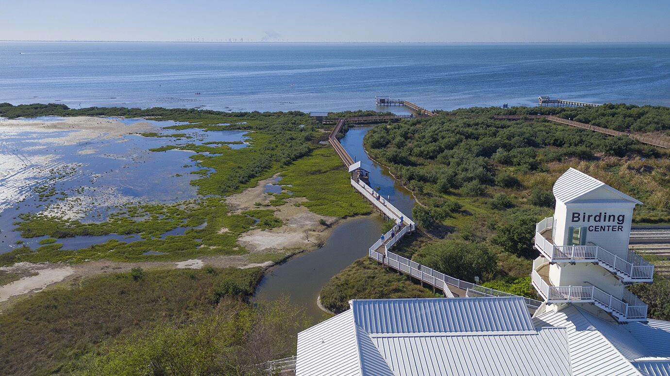 A coastal area with a bridge leading to a building labeled "Birding Center".