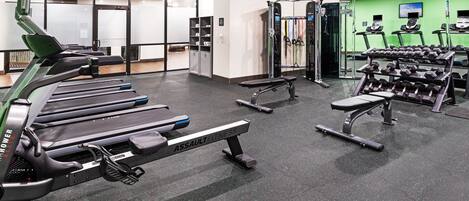 A gym with treadmills, dumbbells, and weight machines.